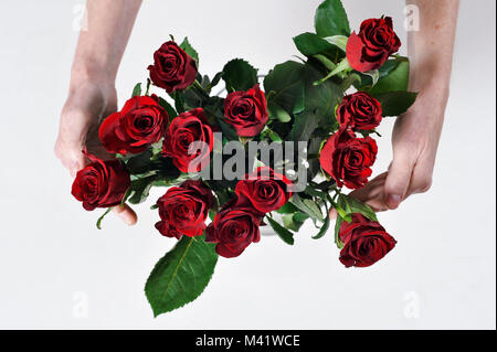 Bois de fleurs d'être organisés pour une occasion spéciale comme la Saint-Valentin. Coupe femme les tiges des fleurs après les arrangeant. Banque D'Images