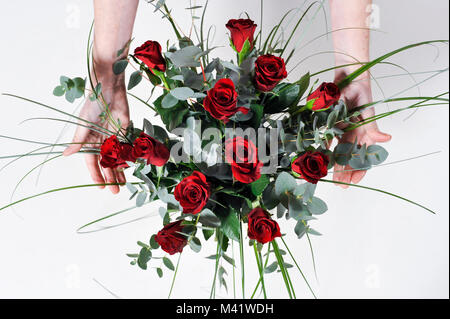 Bois de fleurs d'être organisés pour une occasion spéciale comme la Saint-Valentin. Coupe femme les tiges des fleurs après les arrangeant. Banque D'Images