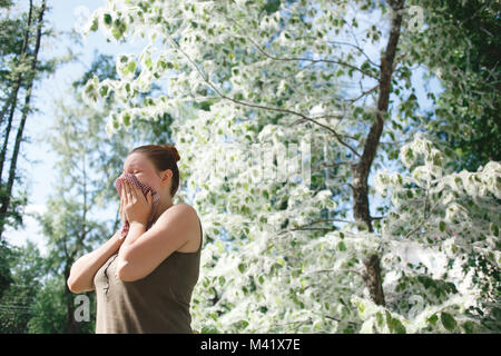 Jeune femme souffrant printemps allergie au pollen. Saison de floraison peuplier Banque D'Images