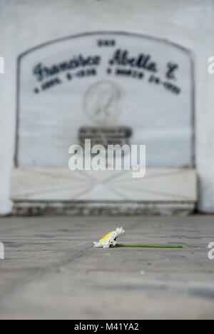 Une seule fleur blanche allongée sur le sol en face d'une pierre tombale dans un cimetière à Bogota, Colombie Banque D'Images