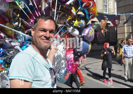 Un vendeur de rue, tenant une grappe de ballons dans un Bristol, Angleterre Banque D'Images