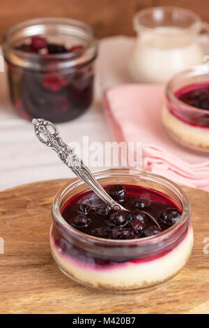 Cheesecake dans un bocal en verre avec les cookies et les baies. Banque D'Images