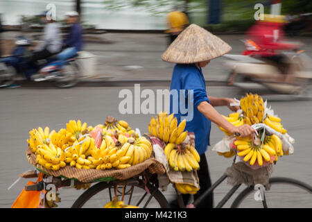 Vietnamese woman selling local de bananes de son vélo dans les rues de Hanoi, Vietnam Banque D'Images