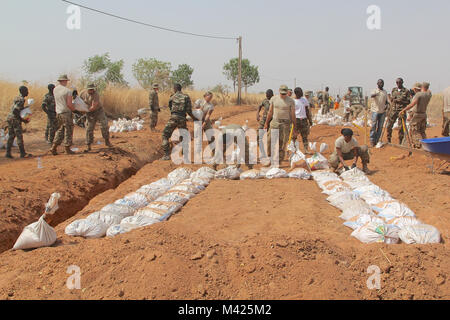 Darby Task Force des soldats de 1er Bataillon, 87e Régiment d'infanterie, 1e Brigade Combat Team, 10e division de montagne, TF Darby et membres de la Base Aérienne 301 Camerounais aviateurs participent à l'Do-Nou Road Le 25 janvier, près de l'emplacement d'urgence Garoua, Cameroun. Le projet utilise des sacs pour réparer les routes qui ont tendance à se laver pendant la saison des pluies. Les dirigeants locaux également le projet pour voir si le Do-Nou méthode peut être utile pour leurs propres projets de réparation des routes. Darby TF sont des soldats servant dans un rôle de soutien pour la lutte contre les militaires du Cameroun l'organisation extrémiste violent Boko H Banque D'Images