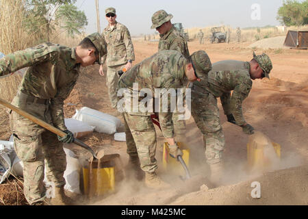 Les soldats de la Force opérationnelle Darby1St bataillon, 87e Régiment d'infanterie, 1e Brigade Combat Team, 10e division de montagne, TF Darby et membres de la Base Aérienne 301 Camerounais aviateurs participent à l'Do-Nou Road Le 25 janvier, près de l'emplacement d'urgence Garoua, Cameroun. Le projet utilise des sacs pour réparer les routes qui ont tendance à se laver pendant la saison des pluies. Les dirigeants locaux également le projet pour voir si le Do-Nou méthode peut être utile pour leurs propres projets de réparation des routes. Darby TF sont des soldats servant dans un rôle de soutien pour la lutte contre les militaires du Cameroun l'organisation extrémiste violent Boko Ha Banque D'Images