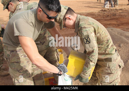 Darby Task Force des soldats de 1er Bataillon, 87e Régiment d'infanterie, 1e Brigade Combat Team, 10e division de montagne, TF Darby et membres de la Base Aérienne 301 Camerounais aviateurs participent à l'Do-Nou Road Le 25 janvier, près de l'emplacement d'urgence Garoua, Cameroun. Le projet utilise des sacs pour réparer les routes qui ont tendance à se laver pendant la saison des pluies. Les dirigeants locaux également le projet pour voir si le Do-Nou méthode peut être utile pour leurs propres projets de réparation des routes. Darby TF sont des soldats servant dans un rôle de soutien pour la lutte contre les militaires du Cameroun l'organisation extrémiste violent Boko H Banque D'Images