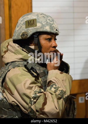 Le s.. Tiffany Cooke, 88e Escadron des Forces de sécurité, ajuste son casque au début d'une arme chimique percer le 31 janvier 2018, à Wright-Patterson Air Force Base, Ohio. Humains et du personnel médical ont reçu une formation à se protéger et aider d'autres personnes dans le cadre d'un exercice à l'échelle de la commande. (U.S. Photo de l'Armée de l'air par R.J. Oriez) Banque D'Images