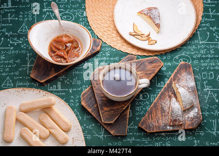 L'heure du thé. Confiture d'abricot, Tarte au fromage cottage et une tasse de thé sur les planches de bois. Des formules mathématiques sur fond nappe Banque D'Images