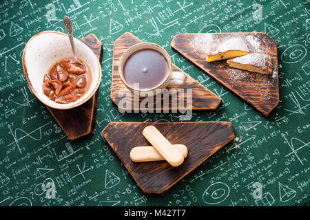 L'heure du thé. Confiture d'abricot, Tarte au fromage cottage et une tasse de thé sur les planches de bois. Des formules mathématiques sur fond nappe Banque D'Images