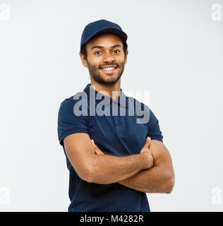 Concept de livraison - Handsome African American man bras croisés plus isolé sur fond studio gris. Copier l'espace. Banque D'Images