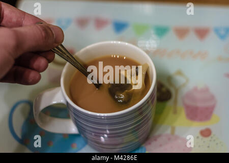 Tasse de thé fait avec un sachet d'être remué avec une cuillère à café. Banque D'Images