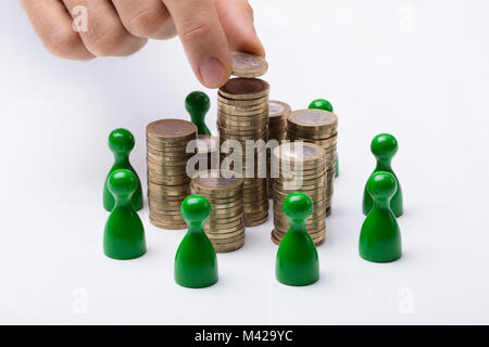 Close-up de l'homme d'affaires mise sur pièce de pile avec des chiffres verts sur fond blanc Banque D'Images