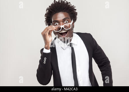 Wow ! Unbeliveble news. Homme en blanc avec des lunettes à la caméra au visage surpris. Studio shot Banque D'Images