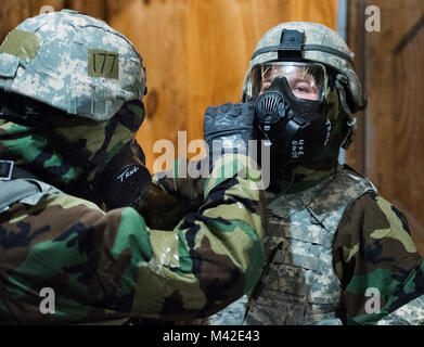 Le s.. Ian Caldwell, 88e Escadron des Forces de sécurité, obtient de l'aide avec son masque à gaz lors d'une arme chimique percer le 31 janvier 2018 sur la base aérienne de Wright-Patterson, Ohio. Humains et du personnel médical ont reçu une formation à se protéger et aider les autres devraient-ils être dans un environnement à haut risque. (U.S. Air Force Banque D'Images