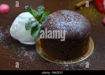 Dessert au chocolat et menthe fondan avec de la crème glacée sur un bacground woodden. Français exquis fondan au chocolat Banque D'Images