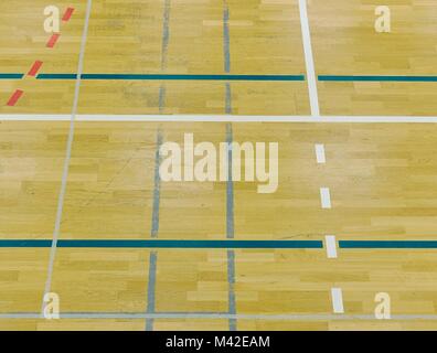 Parquet dans la salle de sport avec de solides et des lignes en pointillé. Réflexion de la lumière sur du parquet ciré avec lignes de marquage coloré Banque D'Images