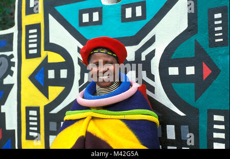 L'Afrique du Sud. Ndebele Mapoch Village, près de Pretoria. peintures murales traditionnelles de tribu Ndebele. Femme avec des vêtements traditionnels. Banque D'Images