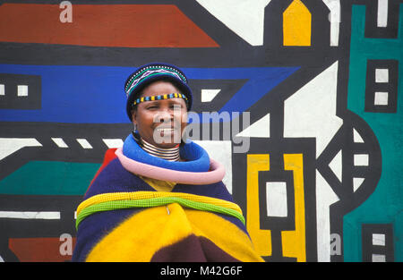 L'Afrique du Sud. Ndebele Mapoch Village, près de Pretoria. peintures murales traditionnelles de tribu Ndebele. Femme avec des vêtements traditionnels. Banque D'Images