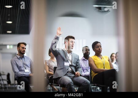 Businessman pose une question lors d'une conférence Banque D'Images