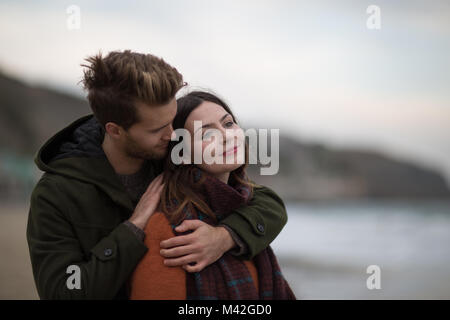 Young adult couple hugging on beach Banque D'Images