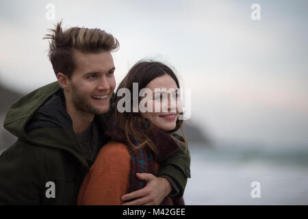 Young adult couple hugging on beach Banque D'Images