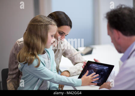 Médecin de famille montrant Mère et fille une échographie de bébé Banque D'Images