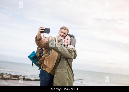 Un couple sur la plage selfies en hiver Banque D'Images