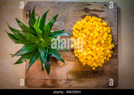 Courge Butternut sur bois table à côté d'une plante ressemble à un ananas juste être hachés. Banque D'Images