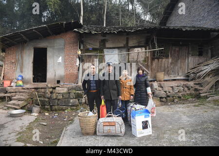 (180214) -- Chengdu, 14 février 2018 (Xinhua) -- Cai Jiwen (1ère L) et sa famille posent pour une photo de groupe en face de leur ancienne maison, avant de passer à leur nouvelle maison, dans la ville de Qidong City dans Jinjilu 1 Hao dans le sud-ouest de la province chinoise du Sichuan, le 3 février 2018. Le 46-year-old travailleur migrant Cai et son épouse rentrer par le train le 1er février. Leur nouvelle maison, l'un des 144 appartements conçus pour les résidents déplacés des zones pauvres, est situé dans un règlement en Jiuyin Village de Jinjilu 1 Hao dans la ville de Qidong City dans le sud-ouest de la province chinoise du Sichuan. (Xinhua/Liu Kun) (zkr) Banque D'Images