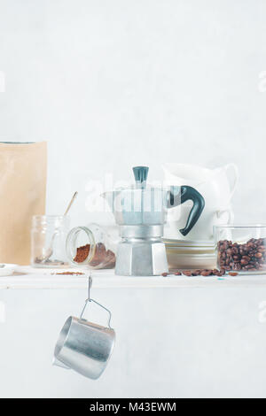 Geyser italienne cafetière sur une étagère avec des ingrédients préparation du café et la verrerie. Infuser le café dans autre façon concept. Touche haut verre photographe Banque D'Images