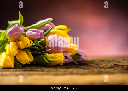 Tulipes. Bouquet de tulipes au printemps jaune et rose sur la table en bois. Banque D'Images