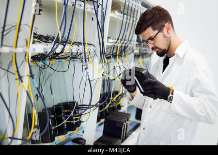 Photo de technicien réseau modems tests en usine Banque D'Images