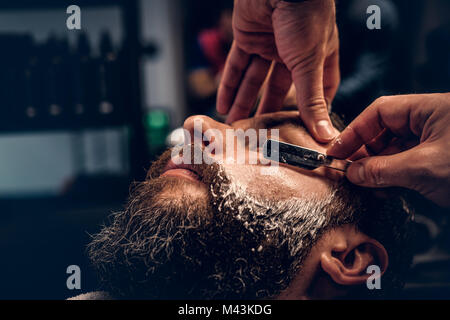 Coiffure rasage homme barbu avec un rasoir. Banque D'Images