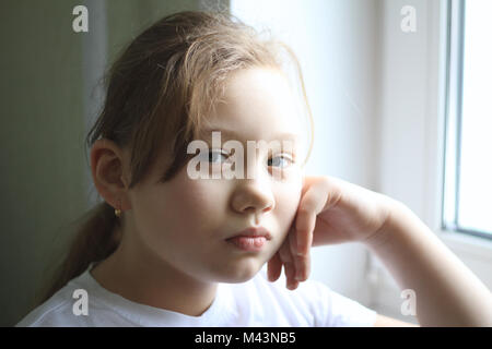 Portrait de jeune fille de 12 ans à la fenêtre près de Banque D'Images