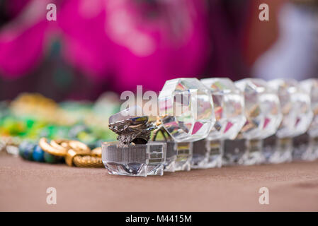 Bagues dans les cases d'affilée sur fond coloré. Cher, luxe bijoux faits de pierres précieuses. Bague de mariage pierre calcédoine Banque D'Images