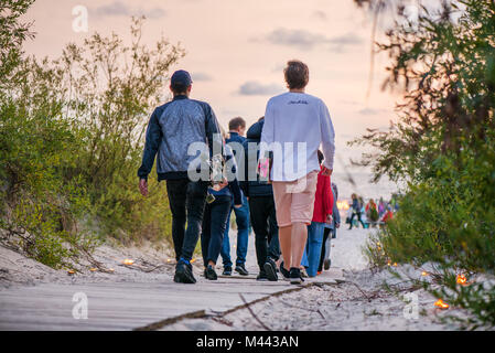 Deux hommes transportant leurs sportifs skate boards et marche vers la mer magnifique coucher du soleil. Banque D'Images