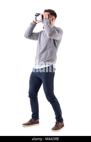 Voir le profil de jeunes phoques barbus smart casual man holding lunettes vr et à la voiture. La pleine longueur du corps portrait isolé sur fond blanc studio. Banque D'Images