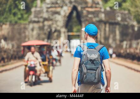 Dans l'ancienne ville. Jeune homme avec sac à dos venant de monuments anciens. Siem Reap, Cambodge Banque D'Images