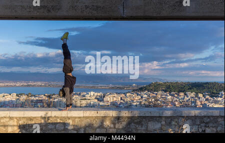 Man doing handstand on wall, Cagliari, Sardaigne, Italie Banque D'Images