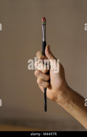 Artiste masculin holding paintbrush en studio des artistes, Close up of hand Banque D'Images