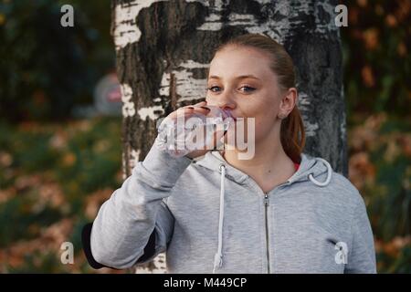 Portrait de jeune femme en formation de l'eau en bouteille potable parc Banque D'Images