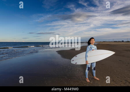 Portrait of young female surfer standing on beach, Tarragone, Catalogne, Espagne Banque D'Images