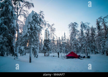 Homme debout à côté de tente dans la forêt couverte de neige, la Russie Banque D'Images