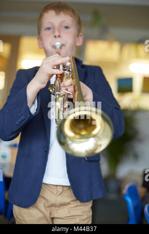 À jouer de la trompette d'écolier en classe à l'école primaire Banque D'Images