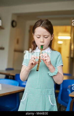 Lycéenne jouant dans l'enregistreur à l'école primaire en classe Banque D'Images