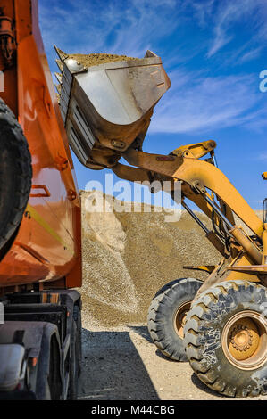 Gravière site de travail avec des camions sur une journée ensoleillée. Banque D'Images