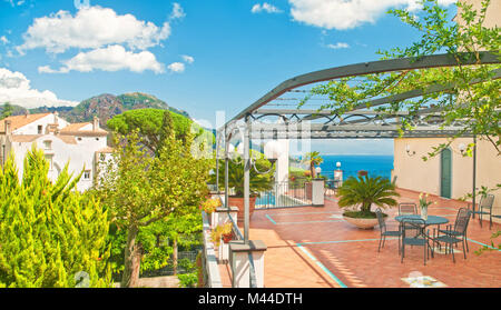 Beau panorama de terrasse avec table et fleurs dans villa avec vue sur la mer méditerranée et les montagnes aux beaux jours d'été à Ravello, côte amalfitaine Banque D'Images