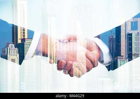 Double Exposure of business people shaking hands over city background Banque D'Images