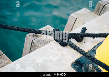 Corde d'amarrage autour d'un bollard on a pier Banque D'Images