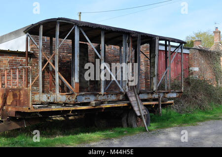 Vestiges d'un wagon sur une remorque dans une ferme près de Paris. Le toit en bois d'origine semble avoir été couvert par de la tôle ondulée. Banque D'Images